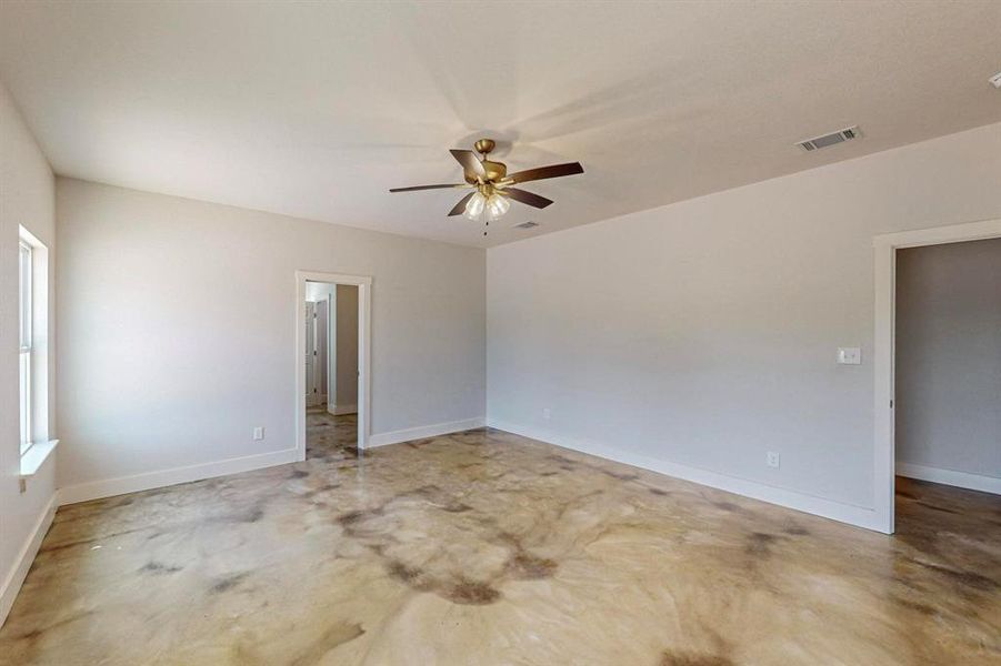 Spare room with concrete flooring and ceiling fan