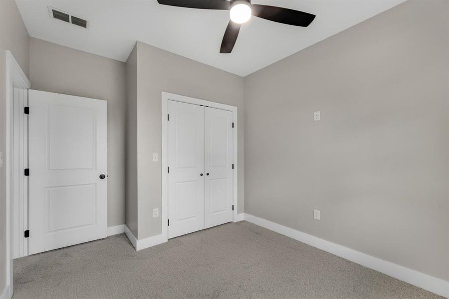 Unfurnished bedroom featuring a closet, ceiling fan, and light colored carpet