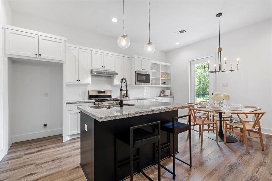 The modern kitchen features an island, quartz countertops, and stainless steel appliances.
