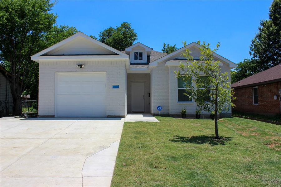 View of front of house featuring a garage and a front lawn