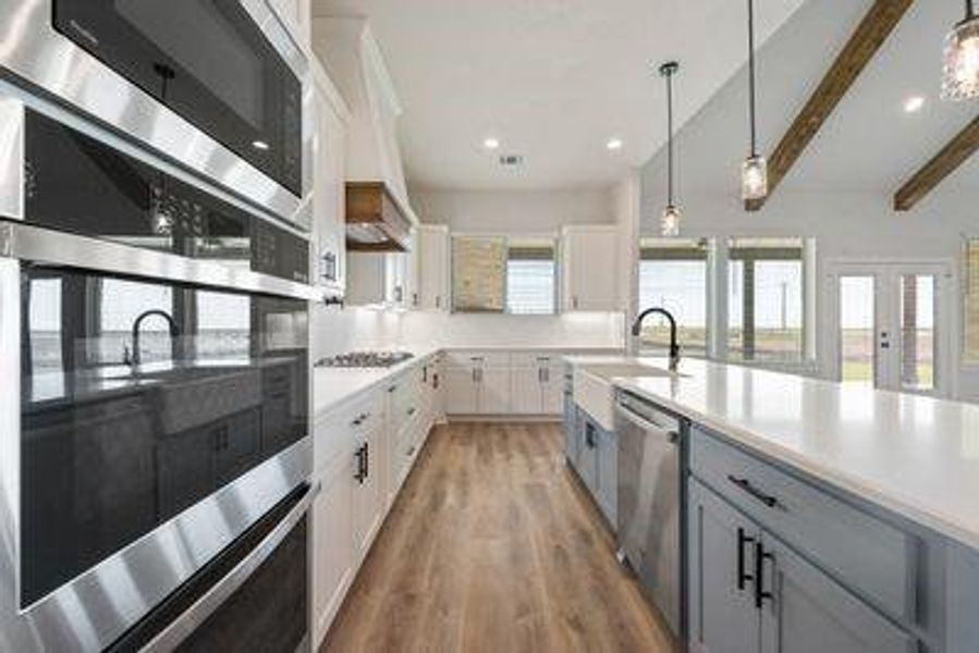 Kitchen with white cabinets, a healthy amount of sunlight, stainless steel appliances, and pendant lighting