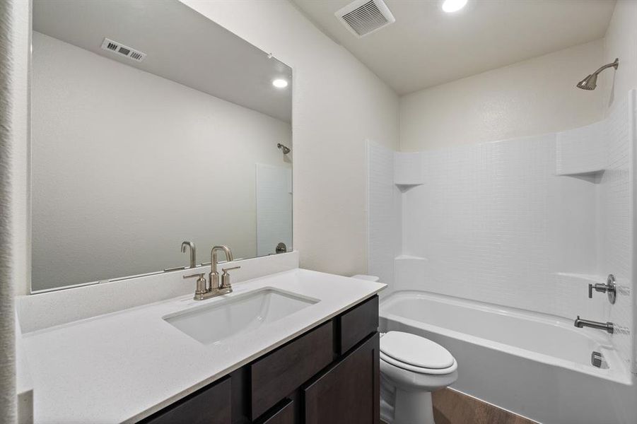 Full bathroom with shower / washtub combination, wood-type flooring, vanity, and toilet