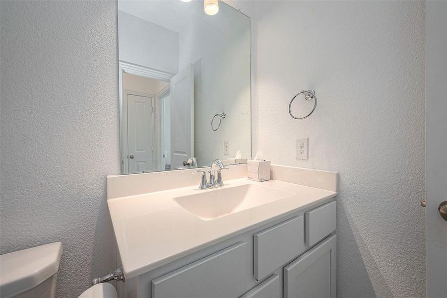 This bathroom features a granite countertop, a sleek faucet, and a large mirror, creating a modern and elegant look.