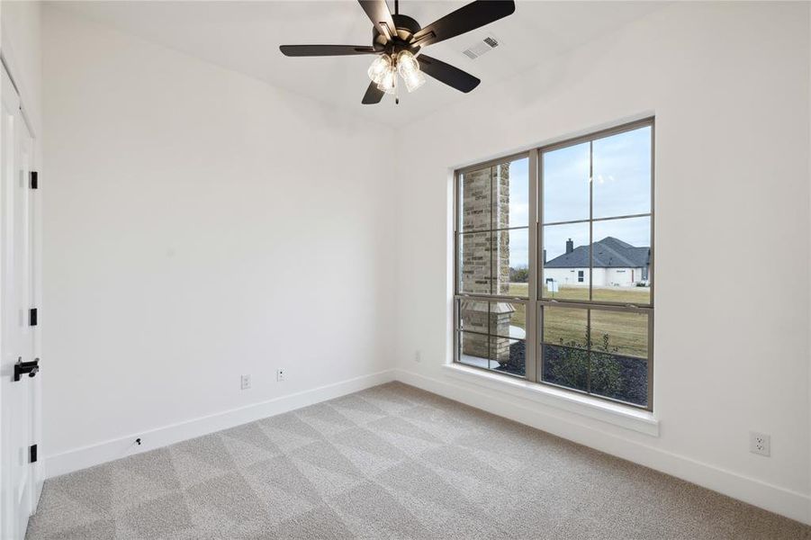 Unfurnished room featuring ceiling fan and light carpet