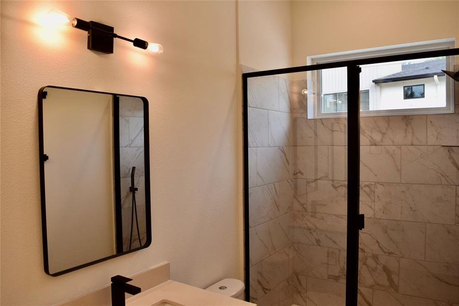 Primary bathroom with large shower, black hardware and window for natural light