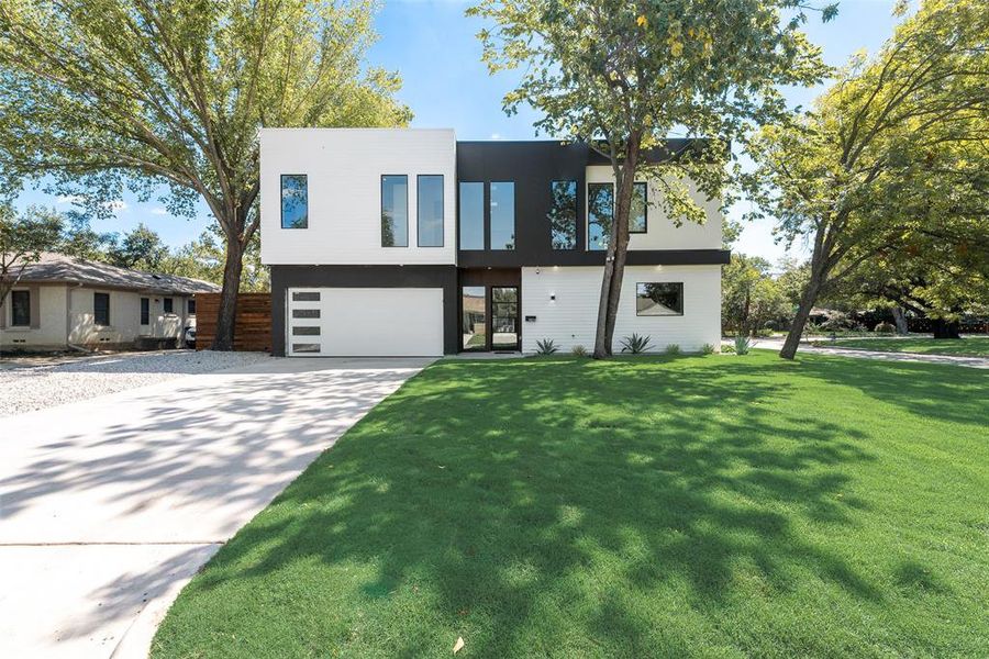 Modern home with a large front yard and a garage