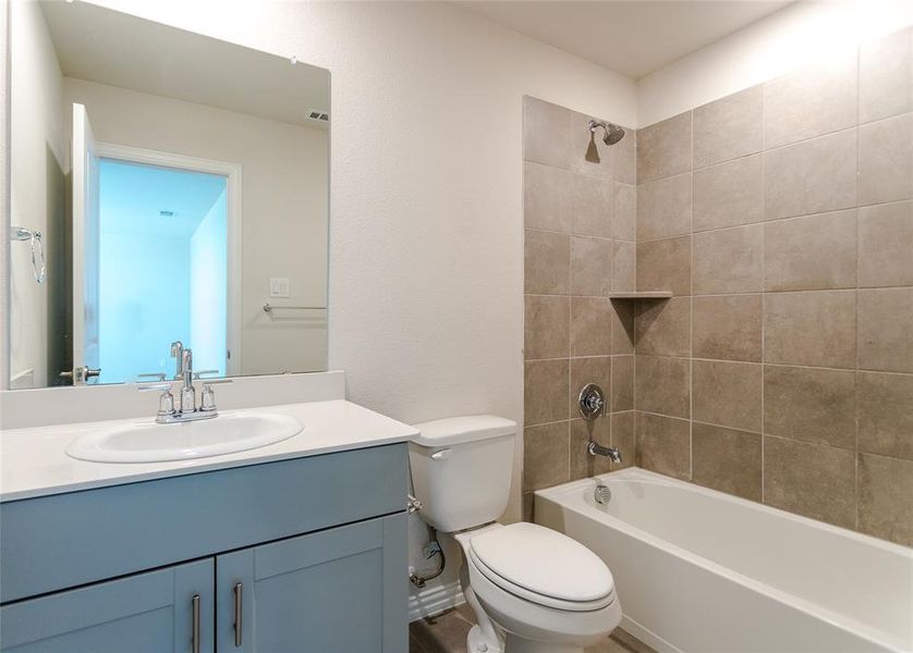 Full bathroom featuring tiled shower / bath, toilet, and vanity