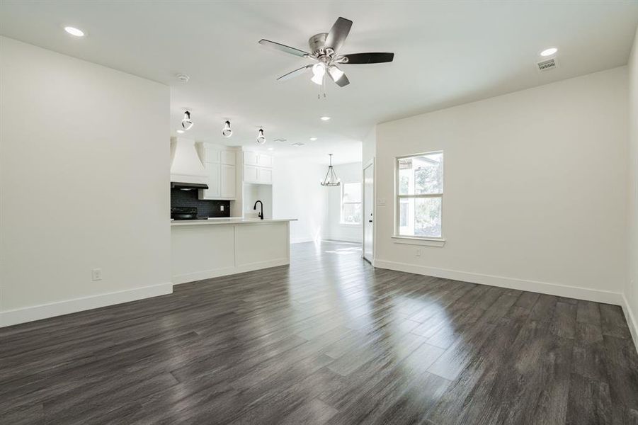 Unfurnished living room with dark hardwood / wood-style flooring, sink, and ceiling fan