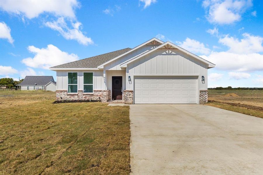 View of front of property with a front lawn and a garage