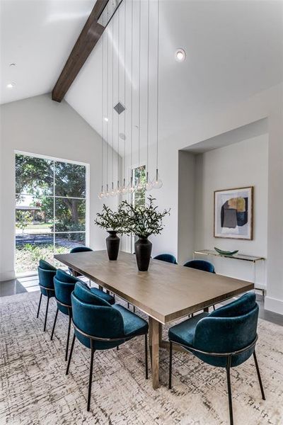 Dining room with vaulted ceiling with beams