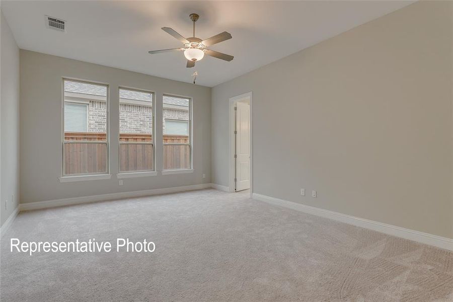 Carpeted empty room with ceiling fan