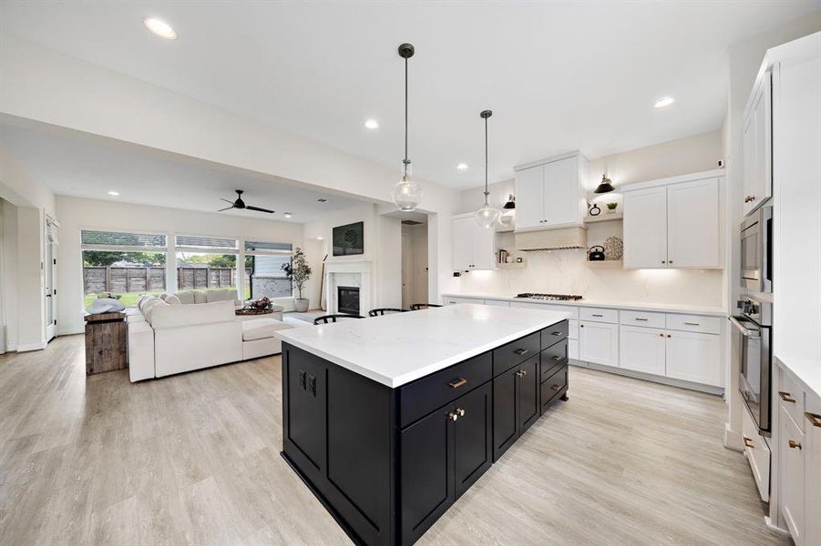 The spacious kitchen features a large central island, meticulously designed with thoughtful details extending to the fixtures and cabinet pulls.