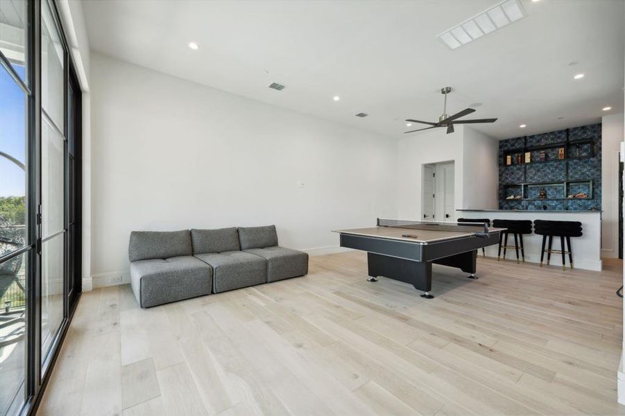 Recreation room featuring light wood-type flooring, pool table, and ceiling fan