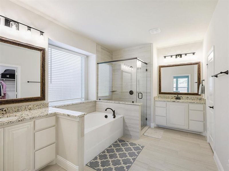 Bathroom featuring vanity and separate shower and tub