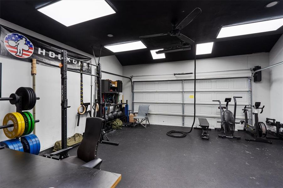 The ULTIMATE MAN CAVE/ GYM/ OFFICE. Seller modified garage to go up 12 feet, added 6 panel lights, red lights and ceiling fan. Also added, Jack shaft garage door opener and wall to wall rubber flooring. Ceiling is also insulated.