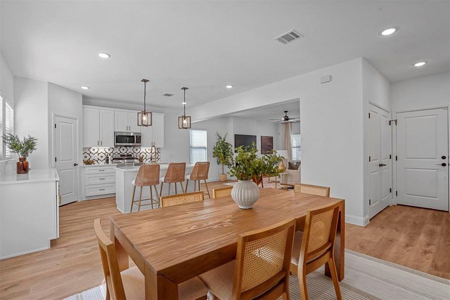 Dining room with light hardwood / wood-style floors and ceiling fan