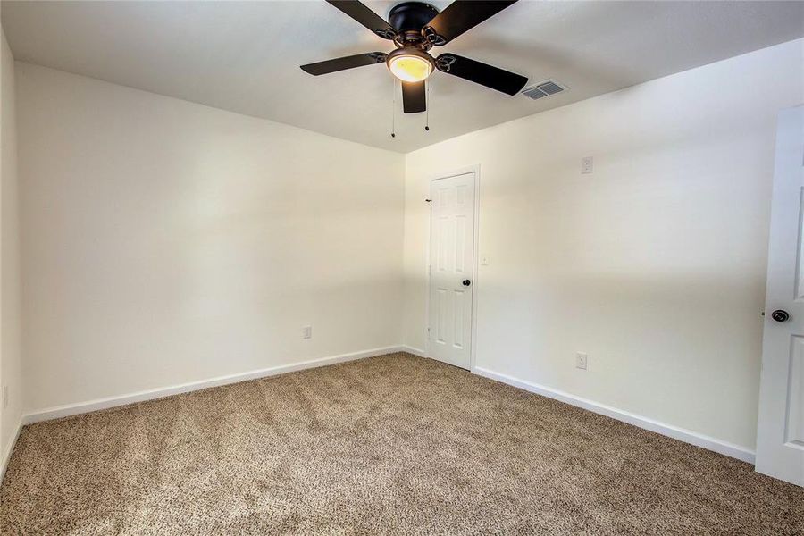 Second room with carpet and ceiling fan