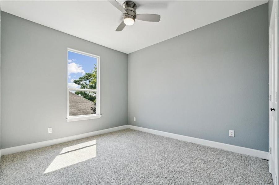 Spare room with ceiling fan and carpet floors