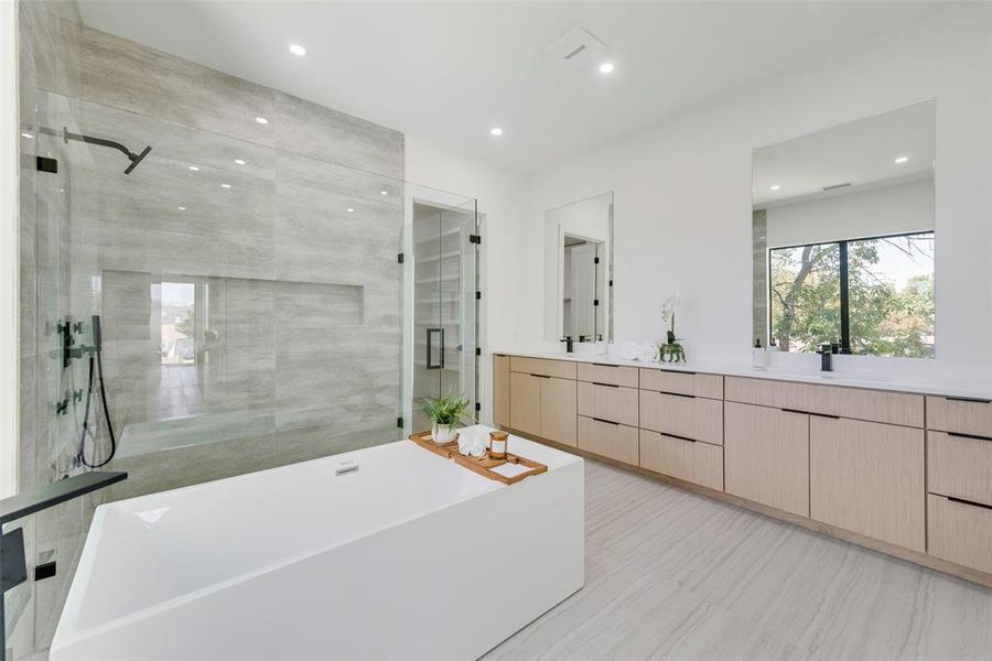 Bathroom featuring vanity and separate shower and tub