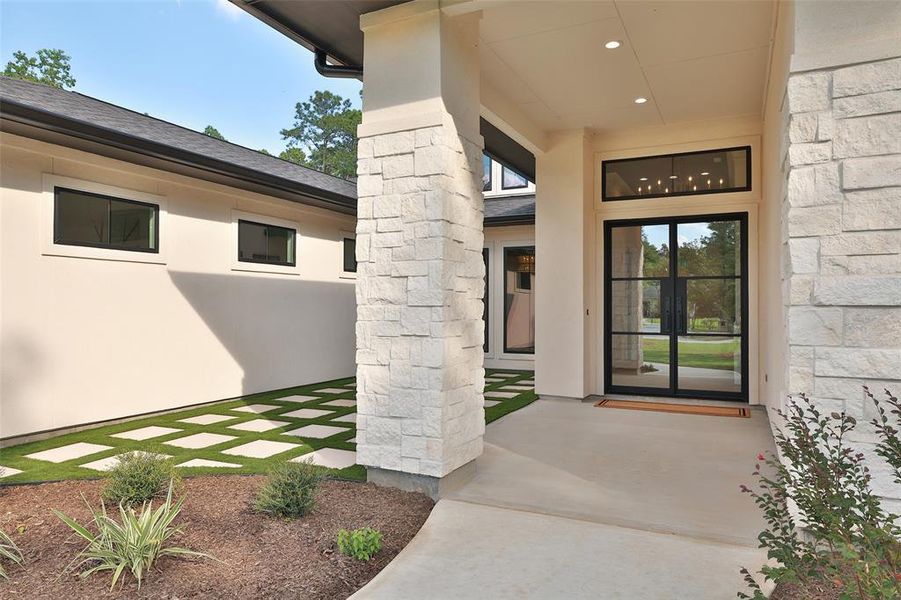 Enter this gorgeous home through the custom metal and glass doors.