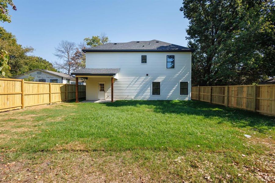 Rear view of property with a lawn