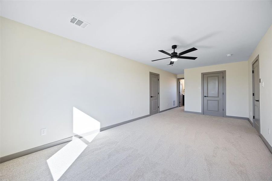 Unfurnished bedroom featuring light carpet and ceiling fan