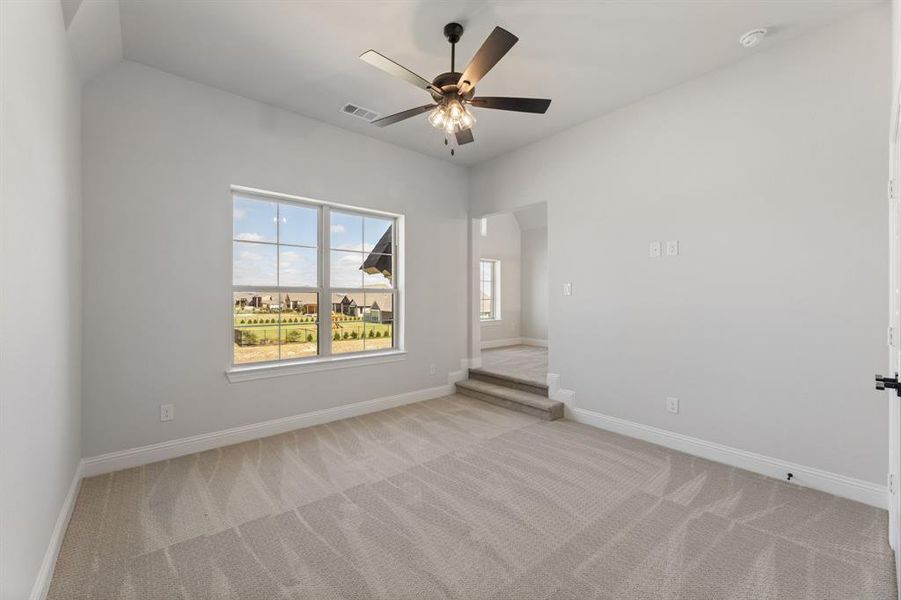 Spare room with ceiling fan and light carpet