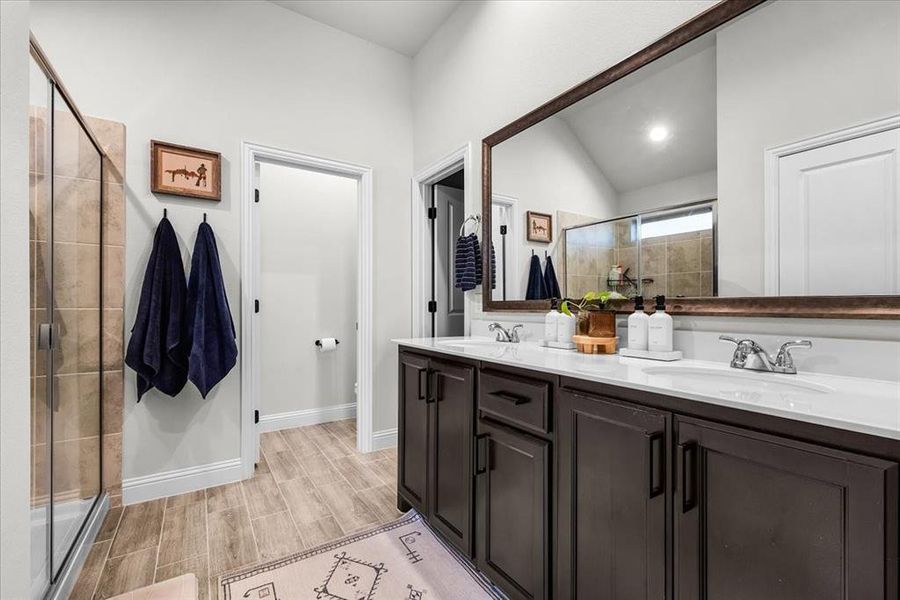 Bathroom featuring lofted ceiling, vanity, and an enclosed shower