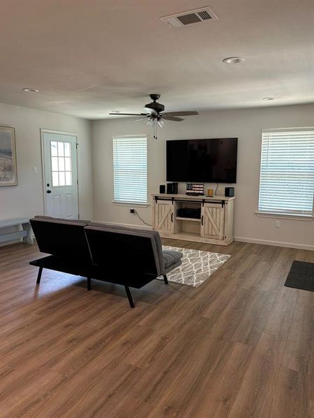 Living room featuring wood-type flooring and ceiling fan