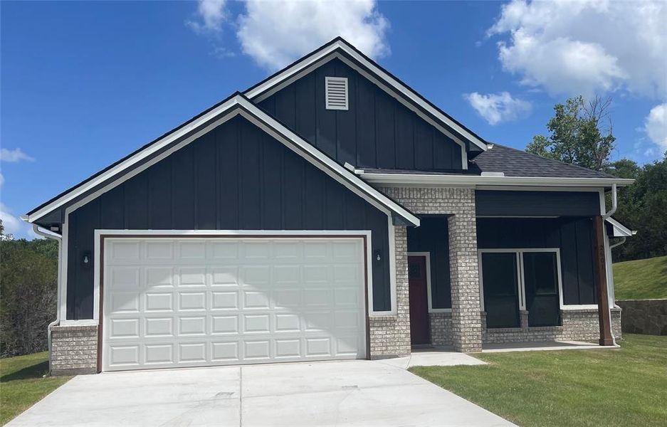 View of front of house featuring a garage and a front yard