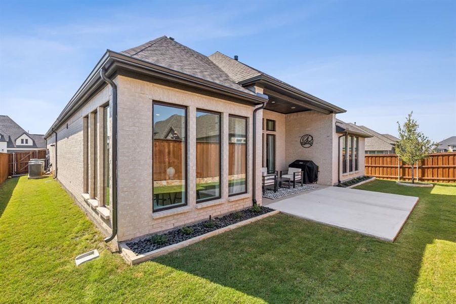 Rear view of house featuring a patio and a lawn