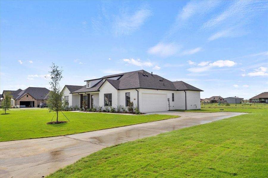 View of front of property featuring a front lawn and a garage