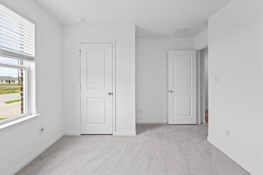 Unfurnished bedroom with a closet and light colored carpet