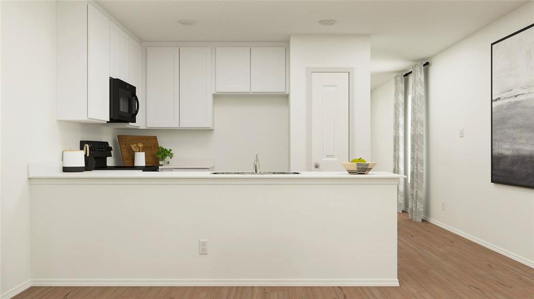 Kitchen featuring white cabinets, sink, kitchen peninsula, black appliances, and light wood-type flooring