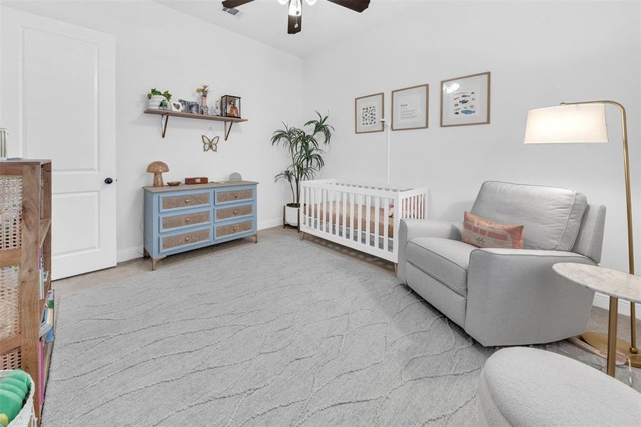 Bedroom featuring a crib and ceiling fan