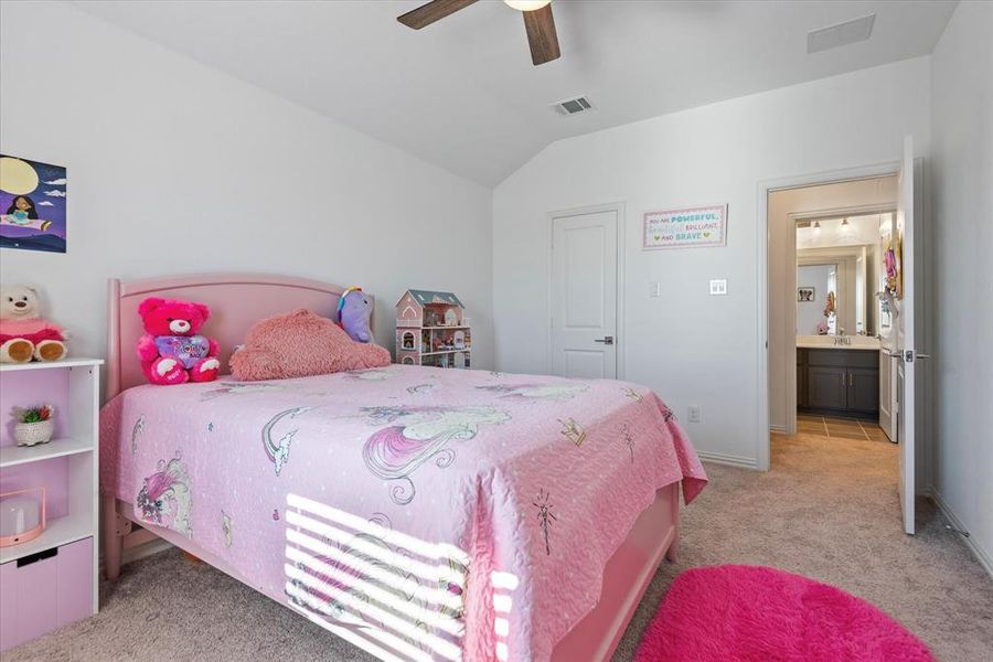 Bedroom featuring ensuite bathroom, vaulted ceiling, light colored carpet, and ceiling fan