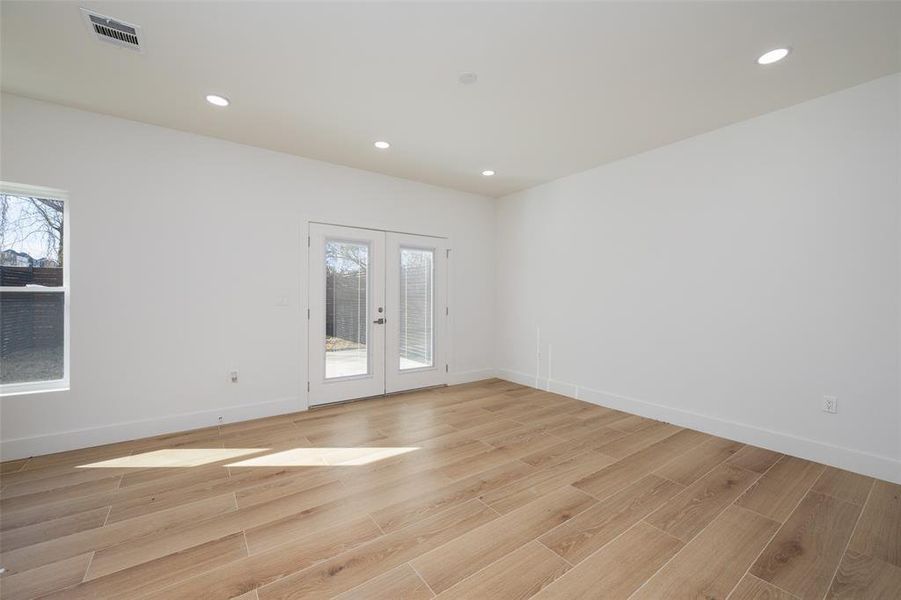 Spare room featuring french doors and light wood-type flooring