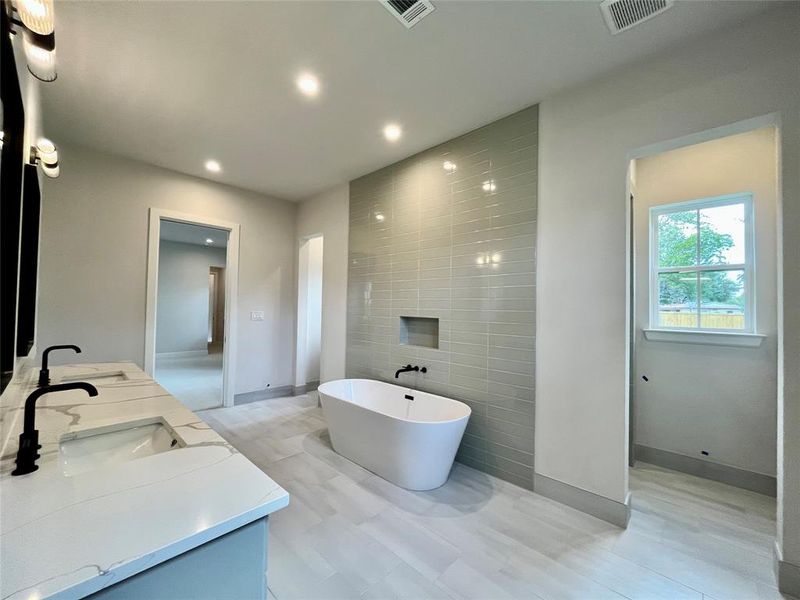 Bathroom featuring a tub, tile walls, and vanity