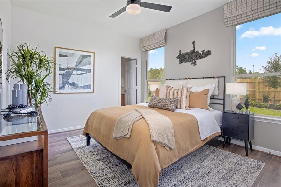 What a wonderful place to come home to, this stunning primary suite greets you with gorgeous wood floors, a warm custom paint, high ceiling, ceiling fan with lighting, large windows allowing in natural light brightening up this spacious primary bedroom!