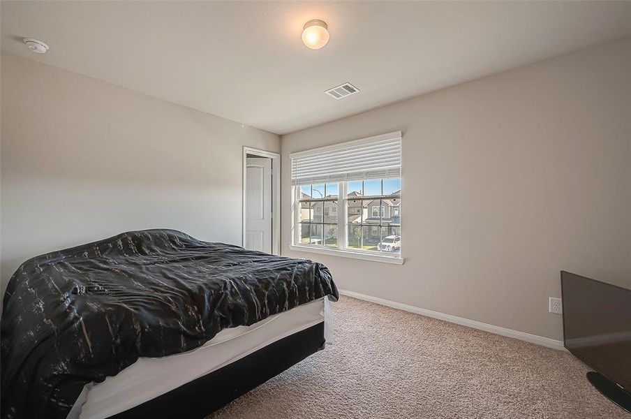 The third bedroom is bright and inviting, perfect for a child's room or guest room. It features ample natural light, providing a cheerful atmosphere.