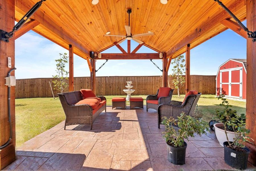 View of patio with ceiling fan, an outdoor hangout area, and a storage shed