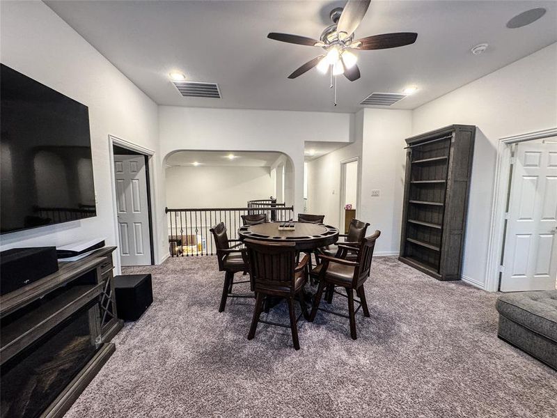 Carpeted dining area with ceiling fan