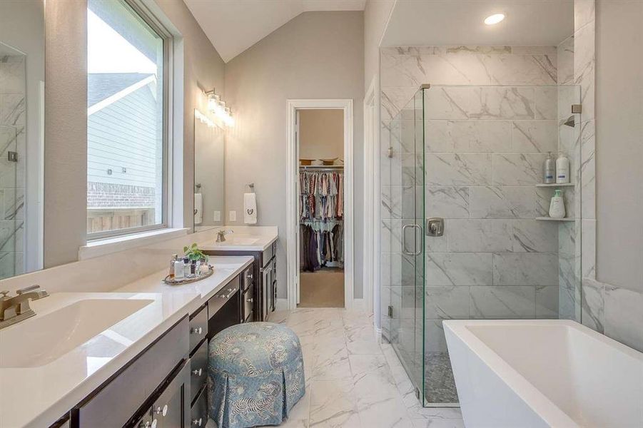 Bathroom featuring plenty of natural light, vanity, independent shower and bath, and vaulted ceiling