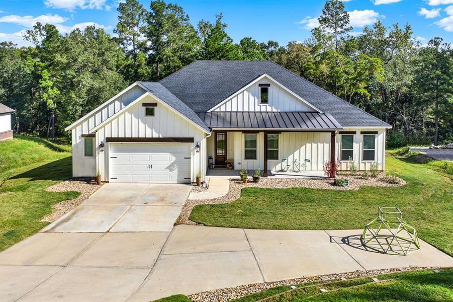 This charming single-story home has a a welcoming front porch ready for rocking chairs or additional plants or flowers to make it even more serene. The property is surrounded by a relaxing wooded backdrop.