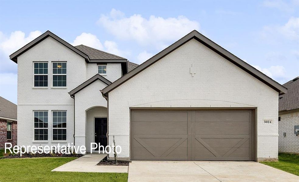 View of front facade featuring a garage and a front yard