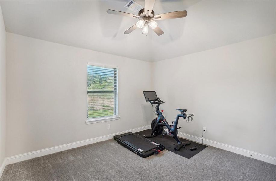 Exercise room with carpet and ceiling fan