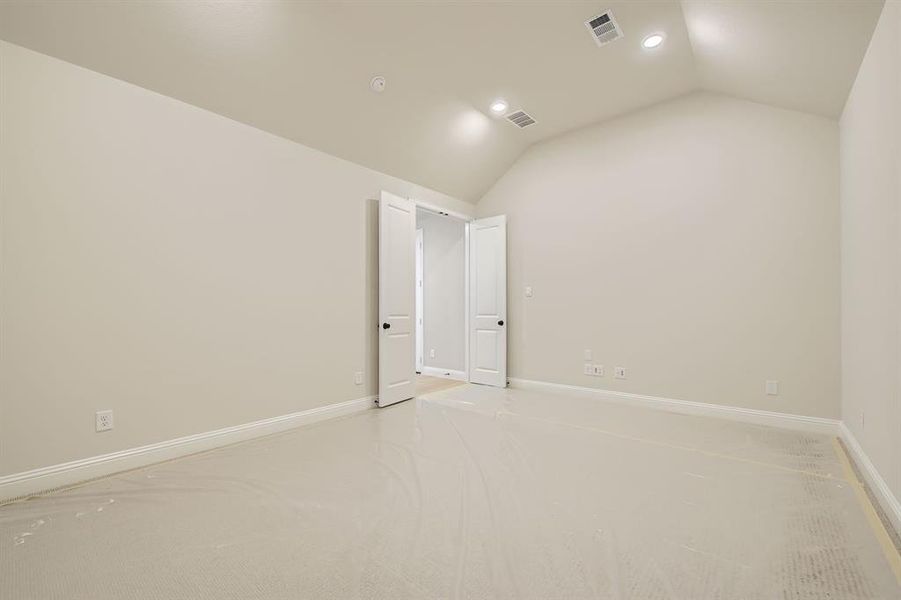 Empty room with lofted ceiling