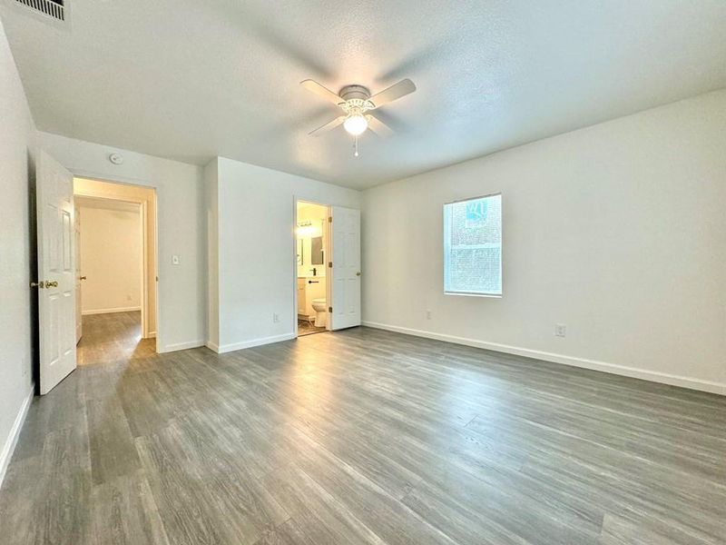 Unfurnished bedroom featuring ceiling fan, dark hardwood / wood-style flooring, a textured ceiling, and ensuite bathroom