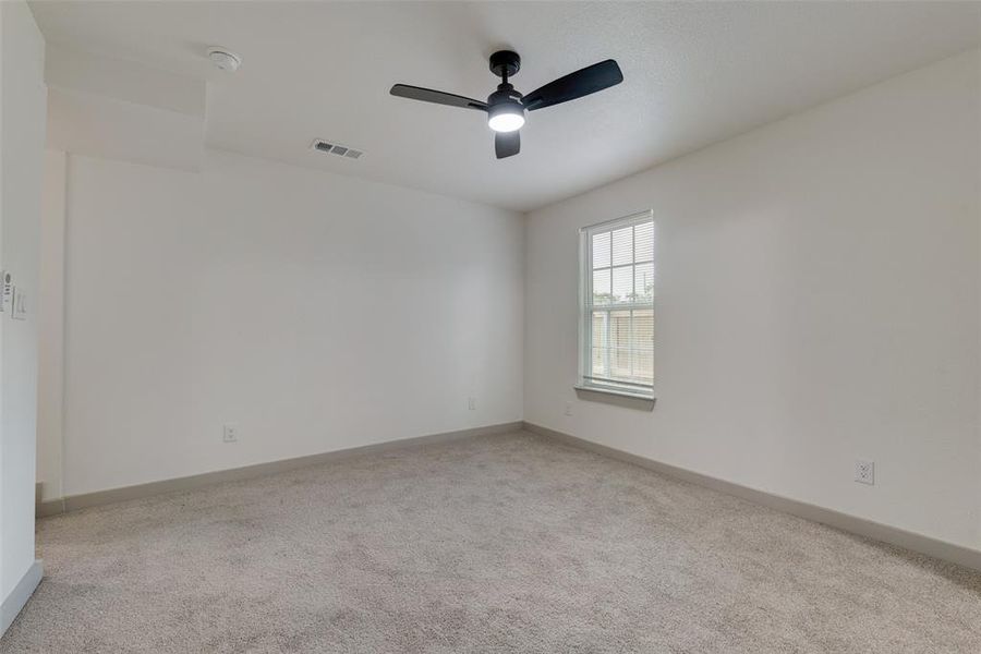 Spare room featuring ceiling fan and light carpet