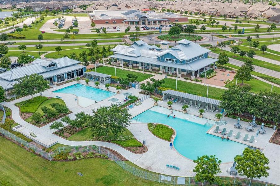 This aerial photo showcases a Pomona community center with expansive outdoor swimming pools, lounging areas, and well-maintained green spaces. The facility is surrounded by a residential neighborhood with easy access to local amenities.